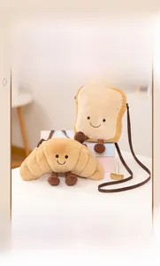 Détail de sacs bandoulière en peluche croissant et toast avec visages souriants brodés