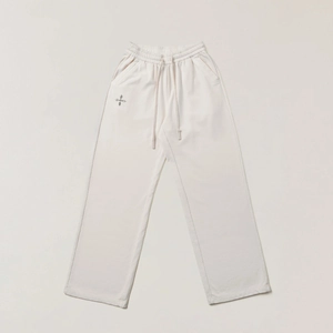 Dettaglio dei pantaloni sportivi vintage crema con coulisse in vita e ricamo a croce