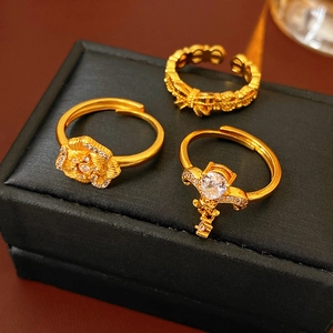 Macro shot of 3-piece vintage gold adjustable rings with zircon flower and textured band