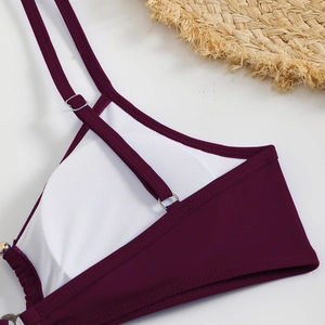 Detail of burgundy bikini top featuring breathable white mesh lining and adjustable straps