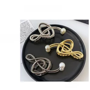 Detailed set of silver gold and grey metal claw clips with white pearl accents