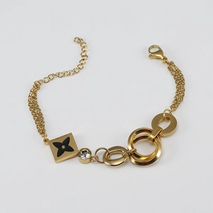 Detailed close-up of 18K gold-plated multilayer chain bracelet with black clover charm