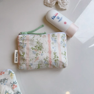 Close-up of floral cotton pouch with pink stripes and simple wish brand label