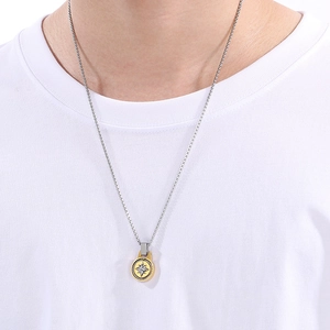 Detail of compass pendant necklace with gold rope border and silver star on male model