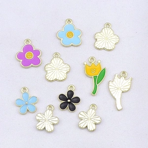 Detailed flat lay of colorful enamel tulip flower pendants for DIY jewelry making