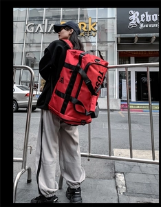 Detailed view of a red large capacity Oxford cloth travel backpack on a model