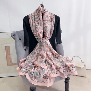 Detail of pink paisley floral scarf draped on black top with elegant silk finish