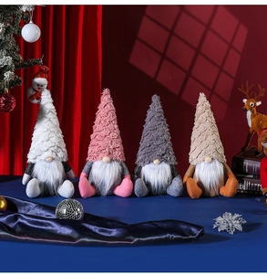 Close-up of four knitted Christmas gnomes with long white beards in luxury festive setting