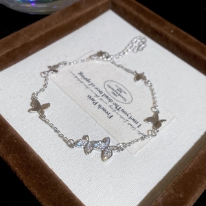 Detailed macro shot of a silver butterfly bracelet with white zircon in a gift box