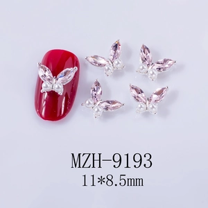 Macro detail of 11x8.5mm pink crystal butterfly nail charms with white pearls