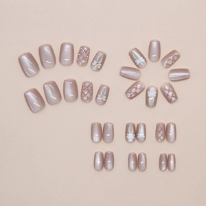 Detail of mauve cat-eye press-on nails with 3D quilted texture and pearl accents