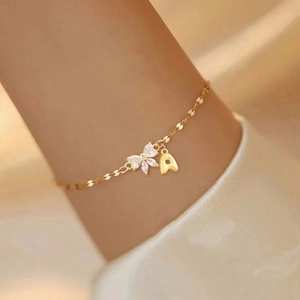 Elegant gold chain bracelet with zircon flower and letter A charm worn on wrist