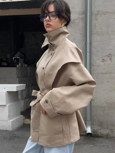 Detail of beige faux leather trench coat with stand collar and belted waist design