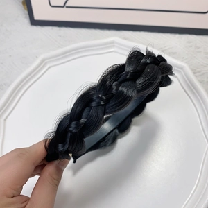 Detailed view of the thick black braided fishtail headband texture and non-slip inner teeth