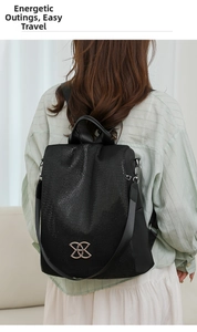 Close-up of a black woven anti-theft backpack with gold logo worn by a model