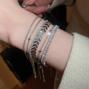 Detail of silver five-piece bracelet set with zircon stones on a model wrist