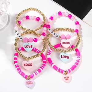 Close-up of pink beaded bracelets with heart pendants and letter beads for Valentine gifts