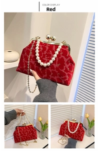 Detail of red velvet shell bag with gold floral embroidery and pearl handle clasp