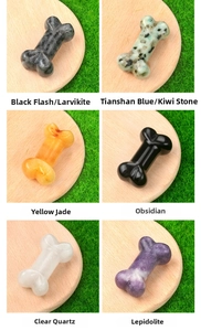 Selection of six bone-shaped natural crystal carvings on wooden bases over grass