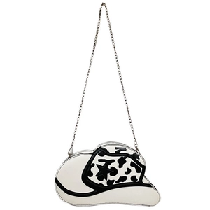 Detail view of white cow print cowboy hat shaped crossbody bag with silver star and chain