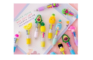 Detailed view of colorful multi-color ballpoint pens with cute cartoon toppers on a notebook