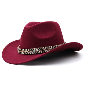 Detail of burgundy western cowboy felt hat with ethnic woven belt and grooved crown