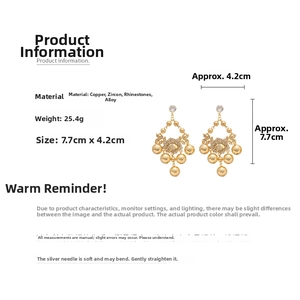 Détail des boucles d'oreilles fleurs dorées avec zircons et glands, 7,7cm sur 4,2cm