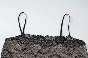 Close-up of black floral lace neckline and thin straps on leopard print dress