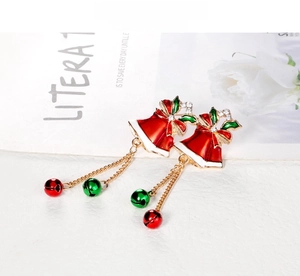 Detail of Christmas bell earrings with red enamel and gold chain tassel accents