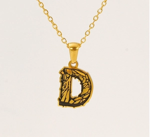 Macro shot of 18k gold letter D pendant with black crackle finish on O-chain
