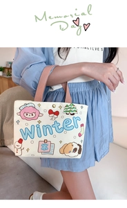 Detail of white canvas tote bag with cartoon sheep and winter motifs and pink handles