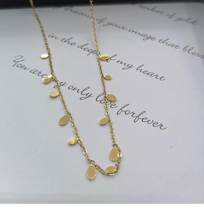 Close-up of gold titanium necklace with oval pendants on a romantic poem gift card