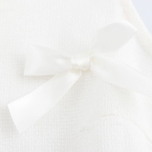 Robe babydoll blanche sans manches à col en V avec tissu texturé et nœud satiné