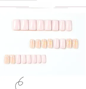 Detail view of pink press-on nails featuring floral art and glossy finish on white background