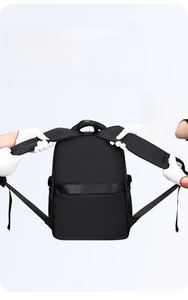 Detail of reinforced wide shoulder straps on black nylon backpack showing heavy load durability