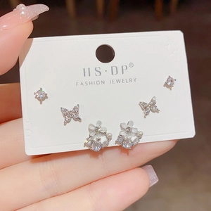 Close-up of s925 silver stud earrings set featuring butterfly and flower designs with zircons