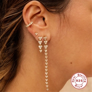 Golden S925 sterling silver heart earrings set with diamonds and tassels on model