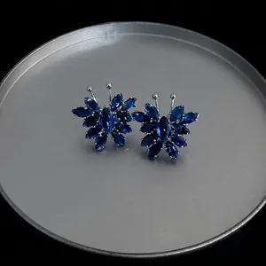 Exquisite silver blue butterfly stud earrings with marquise cut crystal stones on tray