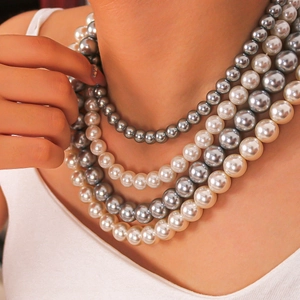 Elegant multi-layer necklace with white and silver-grey pearls on model's neck