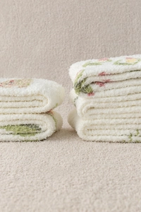 Close-up of thick coral fleece winter socks with soft tulip flower embroidery in cream white