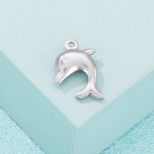 Polished silver hollow dolphin pendant for DIY jewelry on a blue geometric background