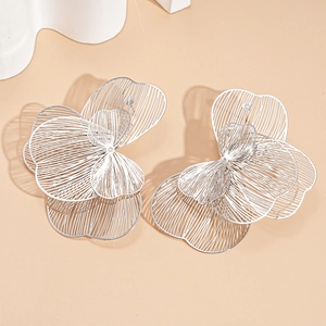 Detailed view of silver hollow flower stud earrings with layered metallic petals