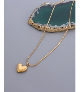 Detailed view of a gold-plated titanium steel chain with a 3D heart pendant on blue