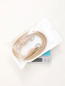 Close-up of the beige leather strap with silver ring clasps on a scale weighing 43g