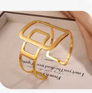 Close-up of a minimalist hollow geometric open cuff bracelet in a bright gold finish