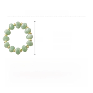 Macro detail of acrylic heart bracelet with jade texture and golden spacer beads