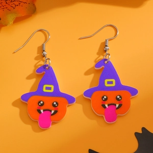 Close-up of Halloween pumpkin earrings with purple wizard hat on orange background
