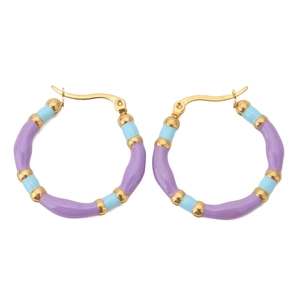 Detail of bohemian hoop earrings with rainbow enamel coating and golden bamboo joints
