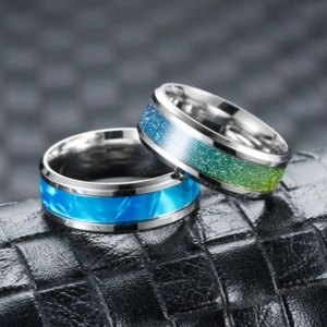 Close-up of titanium steel rings featuring blue and green gradient drip oil design.