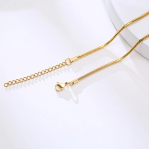 Detail of gold snake chain necklace with adjustable extension and lobster clasp closure